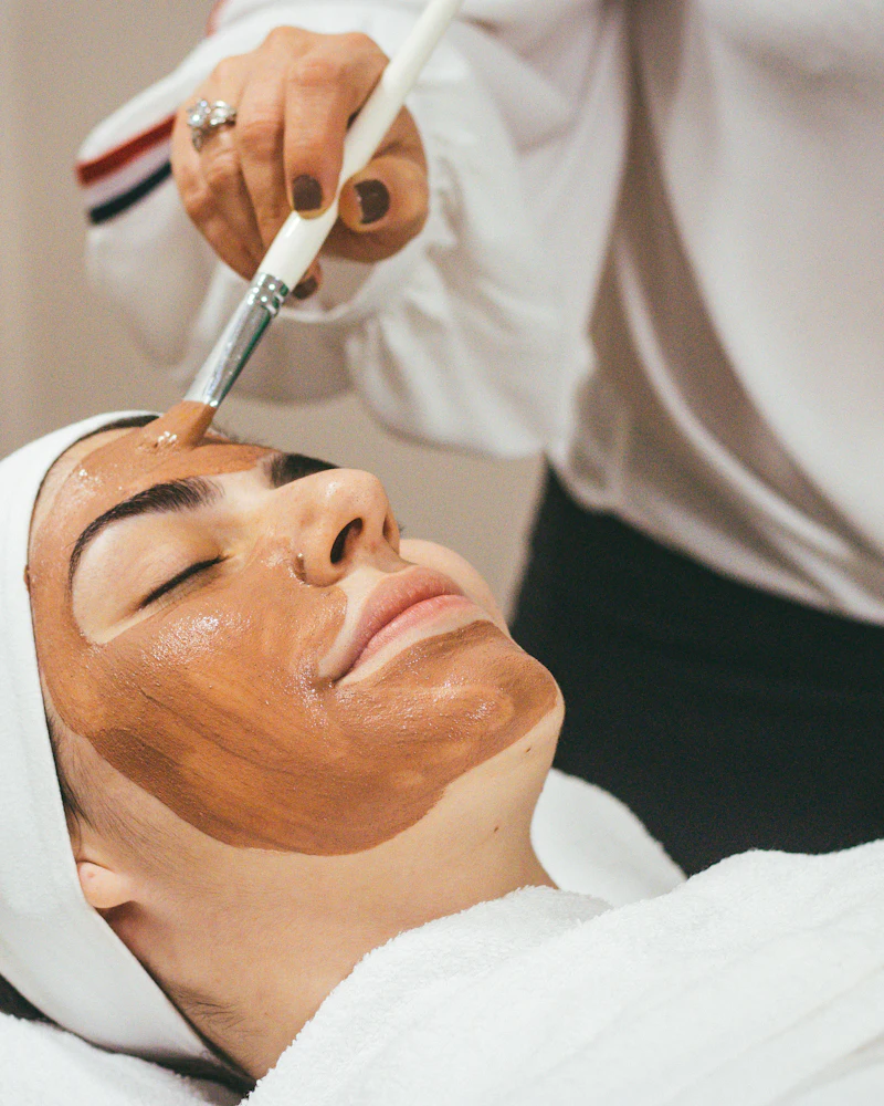 Face pack applied evenly with a brush by a Finenticee student, eyes and lips left clear
